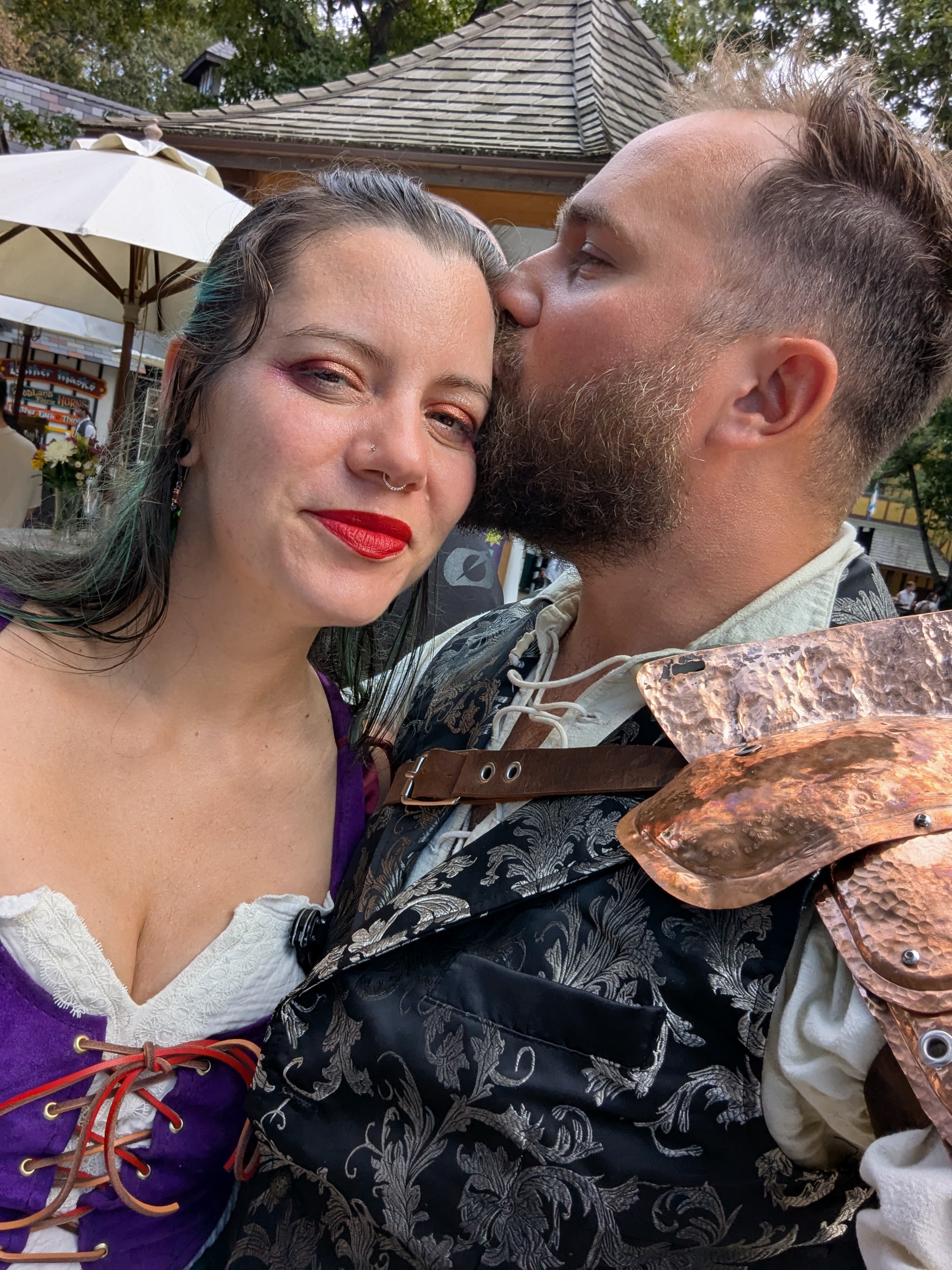 Husband & Wife enjoying each other's company, him kissing her head, both of them happy.